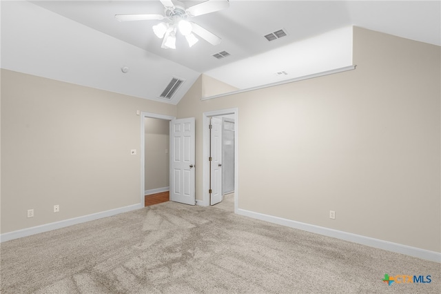 unfurnished bedroom featuring ceiling fan, vaulted ceiling, and light colored carpet