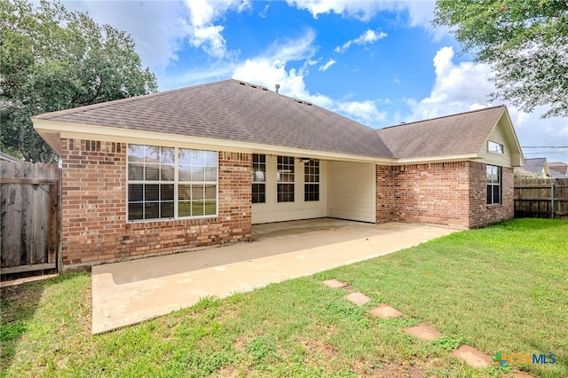 rear view of house with a yard and a patio