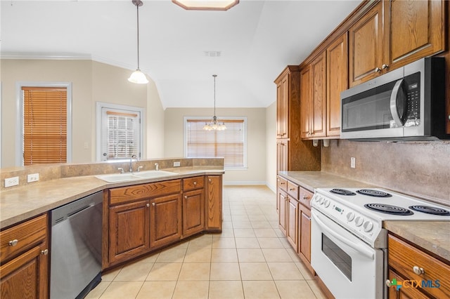 kitchen with appliances with stainless steel finishes, a notable chandelier, hanging light fixtures, sink, and lofted ceiling