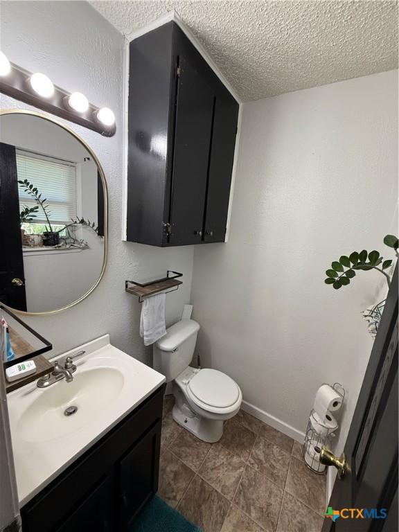 809 Michelle Dr, Copperas Cove, TX 76522 - bathroom featuring vanity, a textured ceiling, baseboards, and toilet