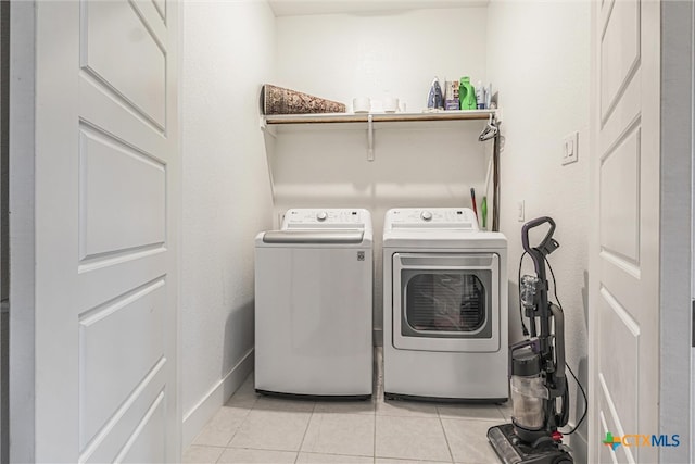 laundry room featuring light tile patterned flooring and separate washer and dryer