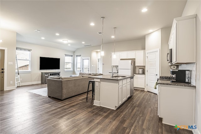 kitchen featuring white cabinetry, white fridge, a kitchen island with sink, and sink