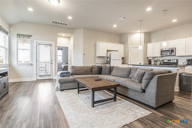 living room featuring lofted ceiling and dark wood-type flooring