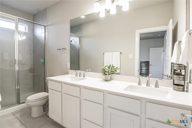 bathroom featuring vanity, toilet, an enclosed shower, and tile patterned flooring