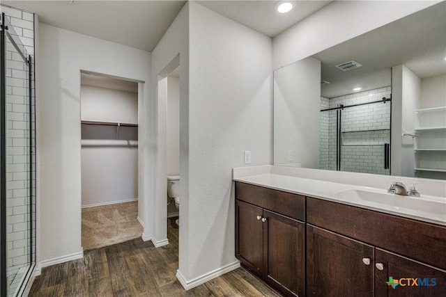 772 Armadillo Dr, Seguin, TX 78155 - bathroom featuring visible vents, wood finished floors, toilet, and a stall shower