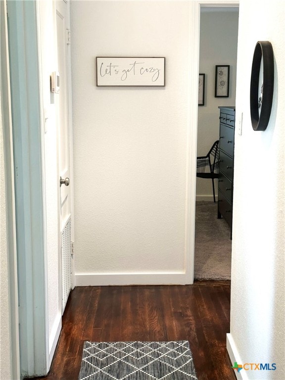 hallway with wood finished floors and baseboards