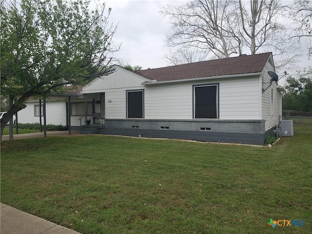 view of front of home with a front yard and a shingled roof