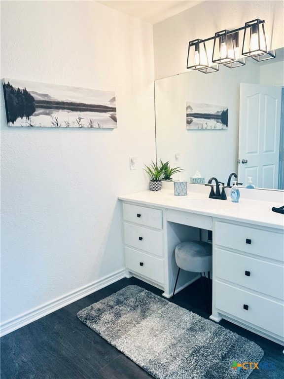 bathroom featuring vanity, baseboards, and wood finished floors