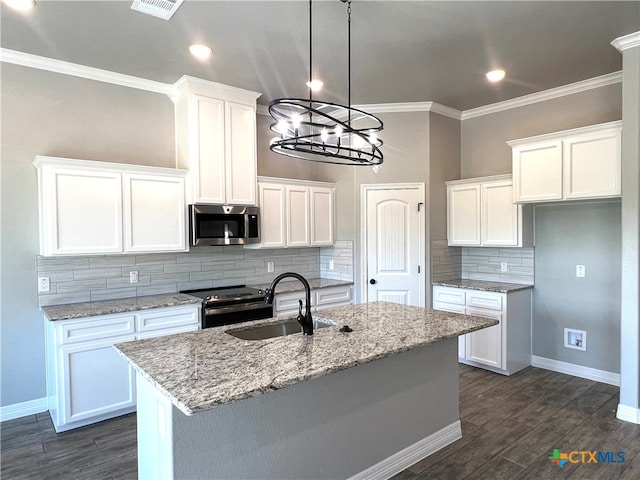 kitchen featuring a center island with sink, appliances with stainless steel finishes, light stone countertops, sink, and white cabinets