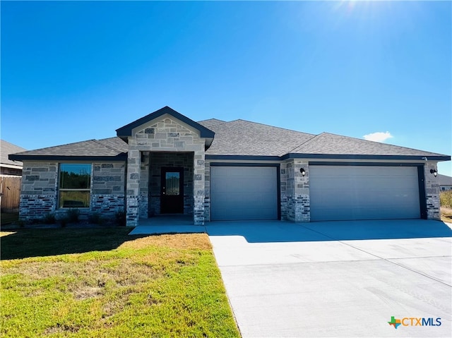 view of front of home with a garage and a front lawn