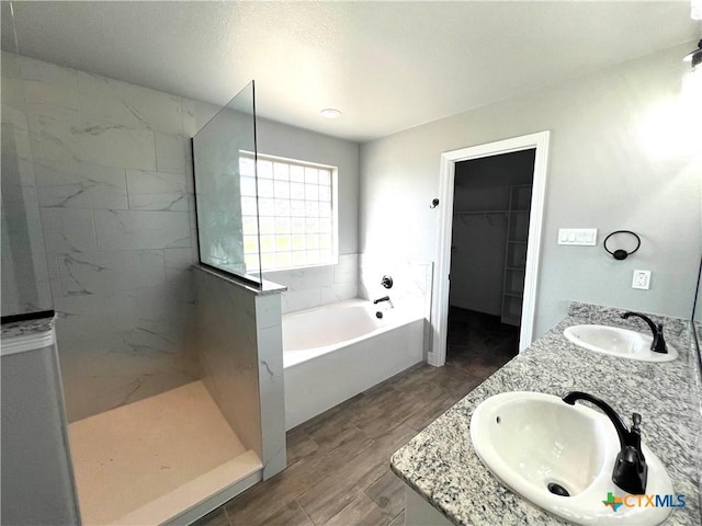 913 Antelope Trl, Temple, TX 76504 - bathroom featuring a bath, walk in shower, a spacious closet, double vanity, and wood finished floors
