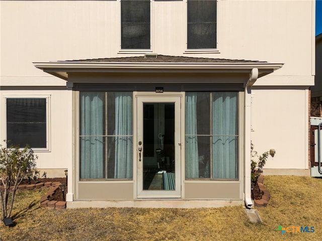 property entrance with stucco siding