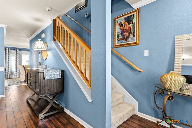 staircase with crown molding, baseboards, and wood finished floors