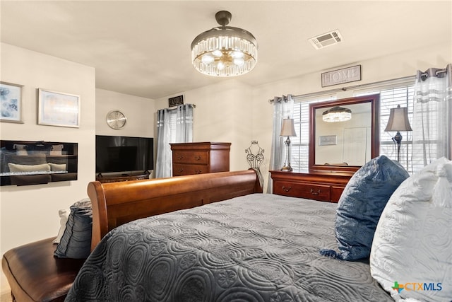 bedroom with visible vents and multiple windows