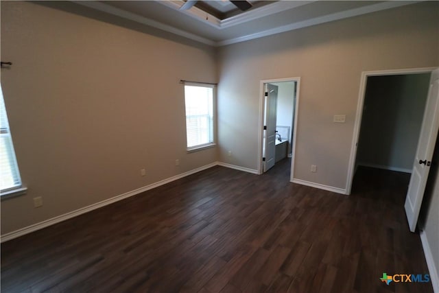 spare room with dark wood-type flooring, crown molding, ceiling fan, baseboards, and a towering ceiling