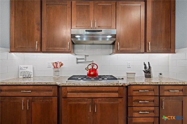 408 O W Lowrey, Salado, TX 76571 - kitchen featuring under cabinet range hood, decorative backsplash, light stone countertops, and stainless steel gas stovetop