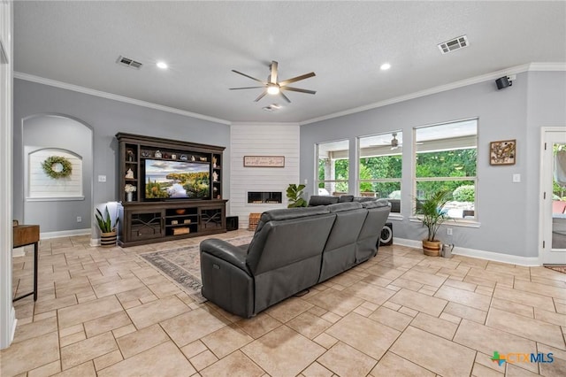 408 O W Lowrey, Salado, TX 76571 - living room featuring a ceiling fan, arched walkways, a fireplace, baseboards, and crown molding