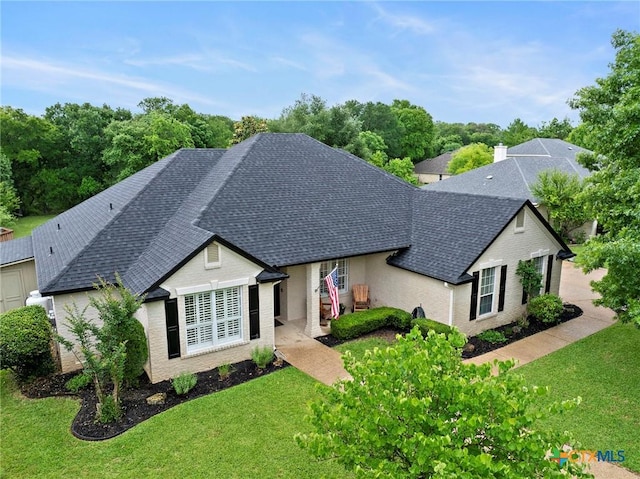 408 O W Lowrey, Salado, TX 76571 - view of front of home featuring roof with shingles, a front lawn, and brick siding