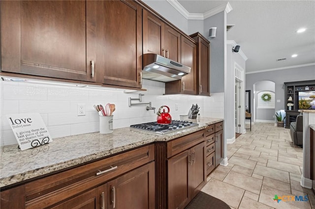 408 O W Lowrey, Salado, TX 76571 - kitchen featuring ornamental molding, stainless steel gas cooktop, under cabinet range hood, arched walkways, and tasteful backsplash