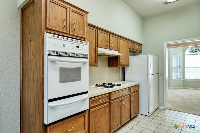 kitchen featuring white appliances and light carpet