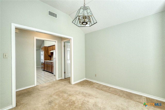 empty room with lofted ceiling, light colored carpet, and a chandelier