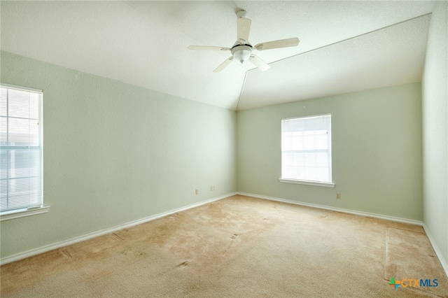 unfurnished room with ceiling fan, light carpet, and vaulted ceiling