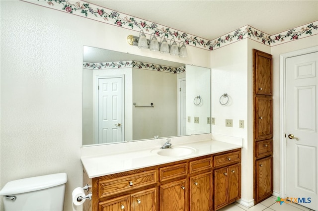 bathroom featuring toilet, vanity, and tile patterned flooring