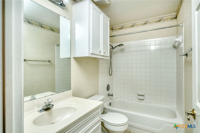 full bathroom with toilet, tiled shower / bath combo, vanity, and a textured ceiling