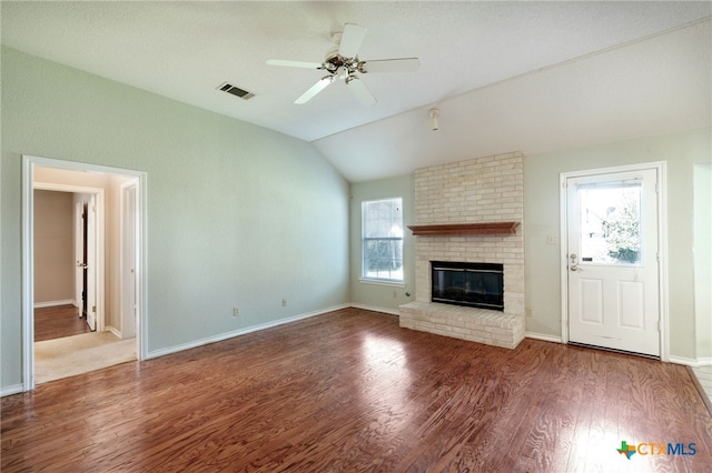 unfurnished living room featuring a fireplace, a wealth of natural light, ceiling fan, and vaulted ceiling