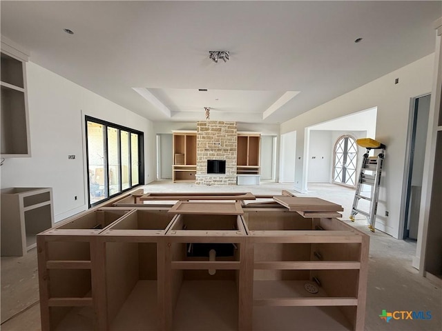1242 Ambrose Dr, Salado, TX 76503 - kitchen with plenty of natural light, a tray ceiling, a large fireplace, and open shelves
