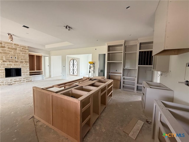 1242 Ambrose Dr, Salado, TX 76503 - kitchen with open shelves, a center island, a stone fireplace, and open floor plan