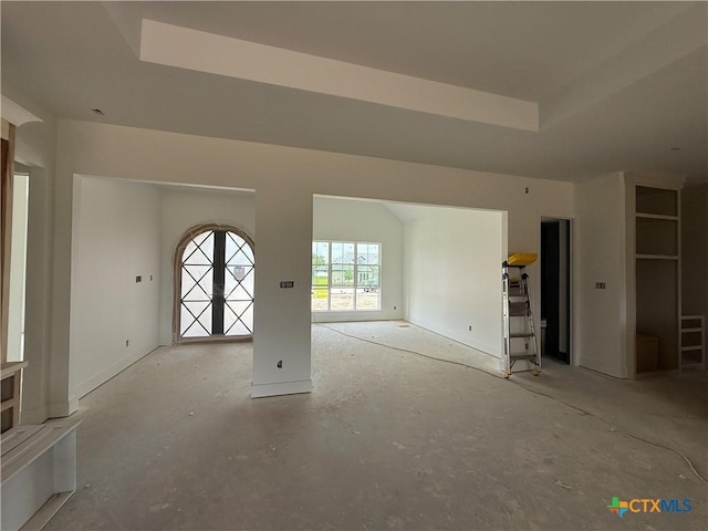 1242 Ambrose Dr, Salado, TX 76503 - unfurnished living room featuring a tray ceiling and unfinished concrete flooring