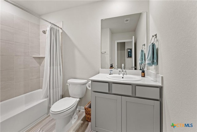 full bathroom with vanity, hardwood / wood-style floors, shower / bath combination with curtain, and toilet