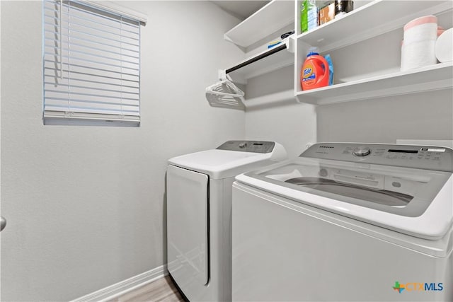 laundry area featuring washing machine and dryer and light wood-type flooring