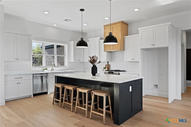 kitchen with white cabinetry, a center island, light hardwood / wood-style floors, and appliances with stainless steel finishes