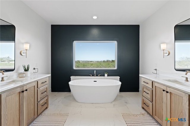 bathroom featuring a bath, vanity, and plenty of natural light