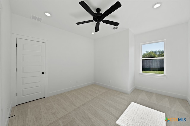 empty room with light colored carpet and ceiling fan