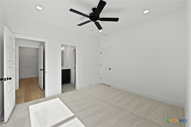 bedroom featuring connected bathroom, ceiling fan, a closet, and light wood-type flooring