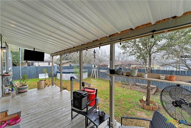 wooden deck featuring a fenced in pool and a lawn