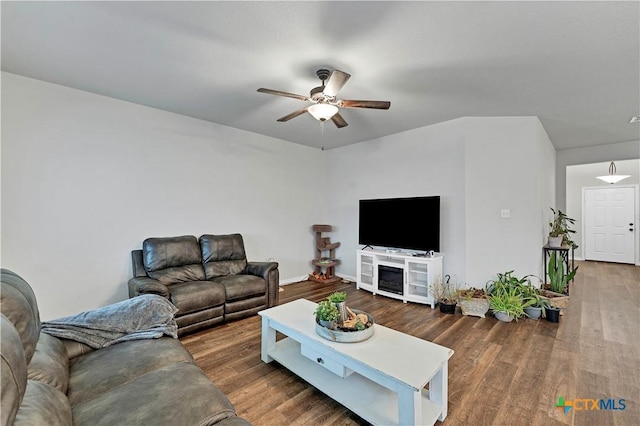 living room featuring dark wood-type flooring and ceiling fan