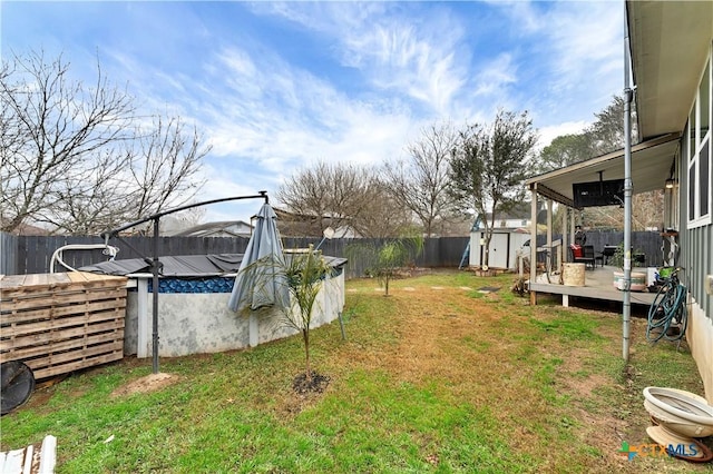 view of yard featuring a swimming pool side deck and a shed