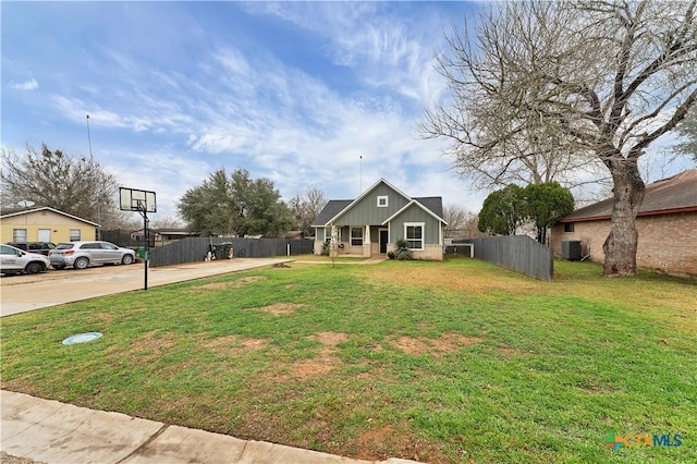 view of front of property with a front lawn and central air condition unit