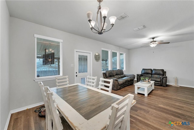 dining space with wood-type flooring and ceiling fan with notable chandelier