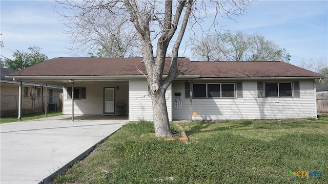 single story home featuring a front yard, concrete driveway, a carport, and fence