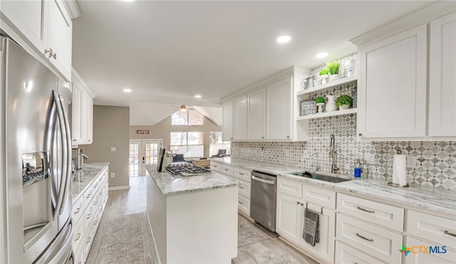 kitchen featuring sink, appliances with stainless steel finishes, light stone countertops, white cabinets, and light wood-type flooring