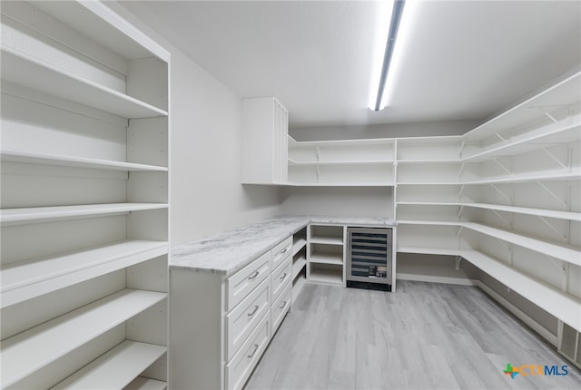 walk in closet featuring light hardwood / wood-style floors and beverage cooler