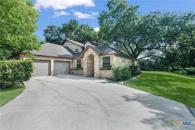 view of front of property featuring a garage and a front lawn