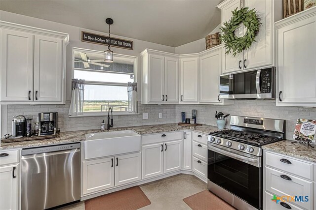 kitchen featuring sink, appliances with stainless steel finishes, white cabinets, light stone countertops, and backsplash