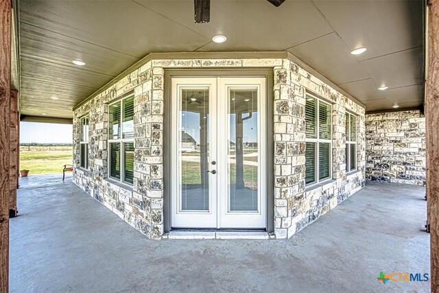 view of exterior entry with french doors and a patio