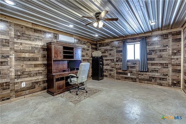 unfurnished office with a wall mounted air conditioner, concrete floors, ceiling fan, and wood walls